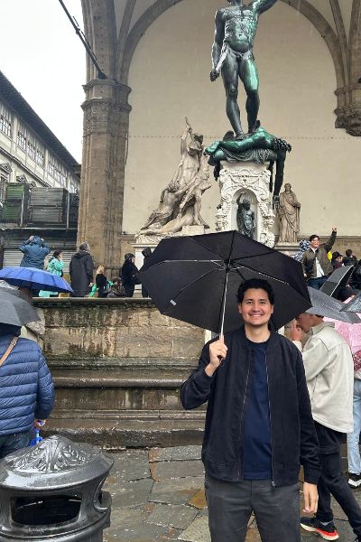 Alfonso smiling with an umbrella